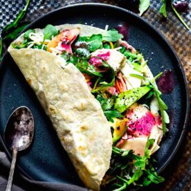 A chicken avocado wrap on a plate ready to eat.