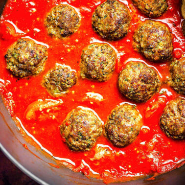 Gluten-free meatballs in a skillet with tomato sauce.