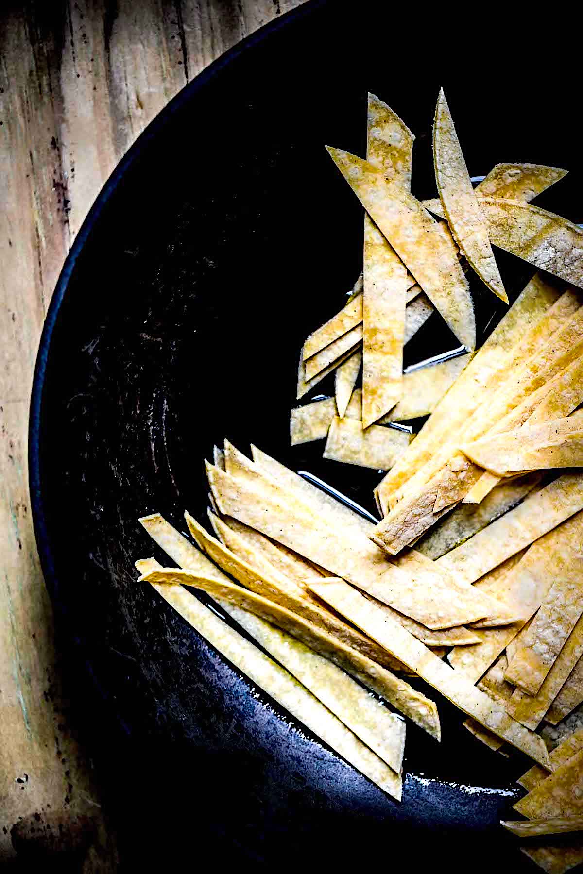 Corn tortillas added to some oil in a skillet.