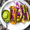 Baja Fish Tacos with sauce on the side overhead shot of white plate